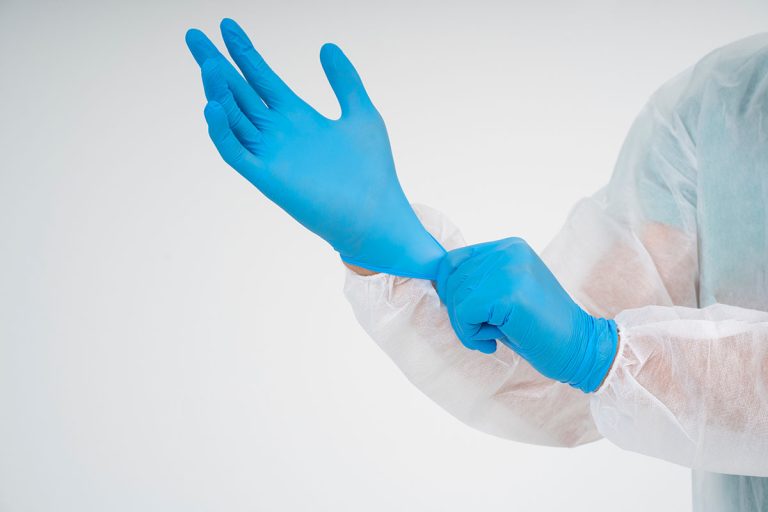Worker putting on blue nitrile gloves